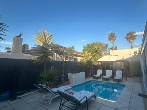 a patio with chairs and a swimming pool at Home Away From Home 6 minutes away from beach in Cape Town