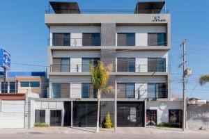 un edificio bianco con una palma di fronte di Industrial Loft King Bed and 2 Office Spaces a Durango
