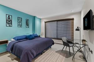 una camera da letto con pareti blu e un letto e una sedia di Industrial Loft King Bed and 2 Office Spaces a Durango