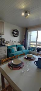 a kitchen and living room with a table and a couch at studio Batlou ménage inclus a la pierre st Martin pyrénée in Arette +12 photos