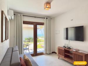 a living room with a couch and a flat screen tv at Beach-Home Pontal de Maceió in Fortim