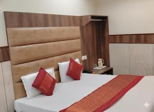 a bedroom with a large bed with red pillows at Raghunath Jammu in Jammu