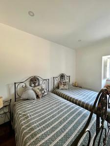 ein Schlafzimmer mit zwei Betten in einem Zimmer in der Unterkunft Casa da Bivó in Figueiró dos Vinhos