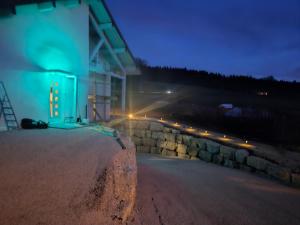 eine Steinmauer neben einem Gebäude in der Nacht in der Unterkunft Le ptit clos in Les Combes