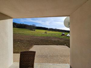 Blick auf ein Feld durch eine offene Tür in der Unterkunft Le ptit clos in Les Combes