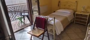 a bedroom with a bed and a chair on a balcony at I Fiori di AminA Le Viole in Pietramelara