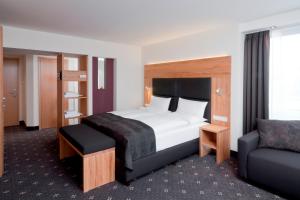een hotelkamer met een bed en een stoel bij Ringhotel Niedersachsen in Höxter