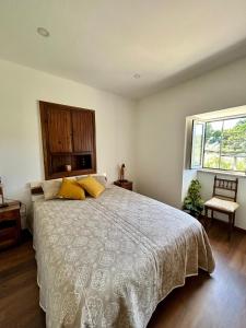a bedroom with a large bed and a window at Casa da Bivó in Figueiró dos Vinhos