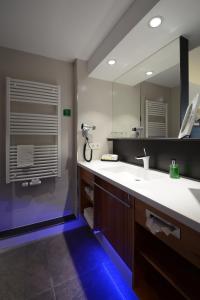 een badkamer met een wastafel en een spiegel bij Ringhotel Niedersachsen in Höxter