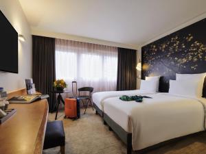 a hotel room with a large bed and a desk at Mercure Paris La Défense in Courbevoie