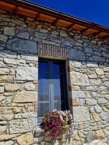 a window of a stone building with a flower pot at Casa S'Urtzula in Sini