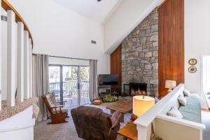 a living room with a fireplace and a stone wall at Chetola: Chestnut 8 in Blowing Rock