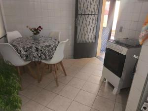 cocina con mesa, sillas, mesa y fogones en Casa Aconchegante em Miguel Pereira, en Miguel Pereira
