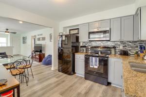 a kitchen with white cabinets and stainless steel appliances at 1 Mi to Truman Library Apt with Large Yard! in Sugar Creek