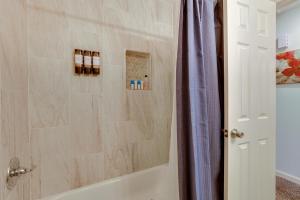 a bathroom with a tub and a shower stall at 1 Mi to Truman Library Apt with Large Yard! in Sugar Creek +26 photos