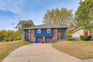 a blue brick house with a driveway at 1 Mi to Truman Library Apt with Large Yard! in Sugar Creek