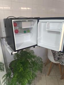 una nevera con la puerta abierta en una cocina en Casa Aconchegante em Miguel Pereira, en Miguel Pereira