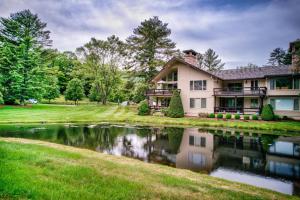 a house with a pond in front of it at Lakes View at Hound Ears in Valle Crucis