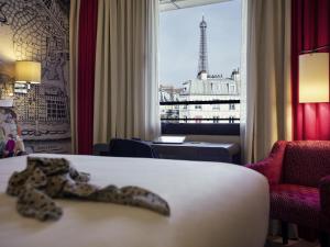 a hotel room with a snake on a bed and a window at Mercure Tour Eiffel Grenelle in Paris +67 photos