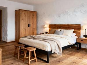 约赫贝格Haus Tauernblick Top 3 und 4的卧室里有一张带木质床头板的大床