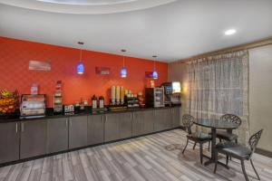 Un restaurante con un mostrador, una mesa y sillas. en Best Western Plus Tech Medical Center Inn, en Lubbock