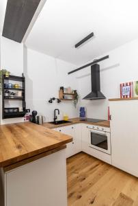 een keuken met witte kasten en een houten aanrechtblad bij Pleasant Park View apartment in Vinkovci