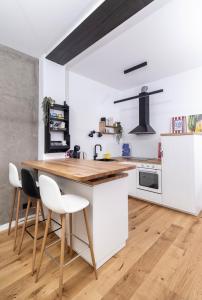 een keuken met een houten tafel en witte kasten bij Pleasant Park View apartment in Vinkovci