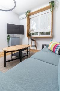 een woonkamer met twee bedden en een tafel bij Pleasant Park View apartment in Vinkovci