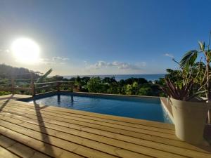 a swimming pool on a deck with a view of the ocean at Villa Franco - Plage de Leroux à 600m - Vue mer exceptionnelle in Deshaies