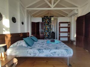 a bedroom with a bed with blue sheets and blue pillows at Villa Franco - Plage de Leroux à 600m - Vue mer exceptionnelle in Deshaies +38 photos