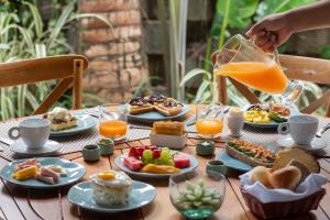a table with plates of food and a pitcher of orange juice at Hotel Spa Nau Royal in Camburi