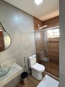 a bathroom with a toilet and a sink and a shower at Pousada Recanto das Estrelas in São Thomé das Letras