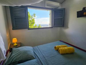 a bedroom with a bed with a window at Lauramar Avocado - Vue Mer et Montagne in Le Morne aux Bœufs +23 photos
