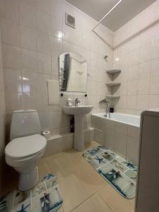 a bathroom with a toilet and a sink and a tub at Воскресенская 1 Набережная 2 кв in Dnipro