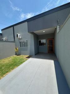 ein graues Gebäude mit einer Seitentür. in der Unterkunft Casa garagem camionete, 2 quartos, espaço para 6 pessoas, casa completa, 5min Centro - Casa 5 in Sinop + 35 Fotos