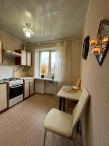 a kitchen with a table and a chair in a room at Воскресенская 1 Набережная 2 кв in Dnipro