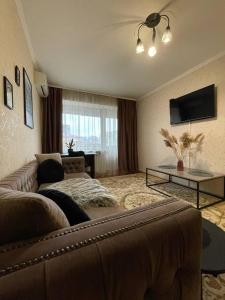 a living room with a couch and a television at Воскресенская 1 Набережная 2 кв in Dnipro