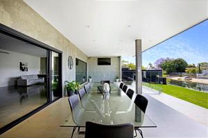 Un comedor con una mesa de cristal y sillas. en Urban Hideaway Pet Friendly, en Gold Coast