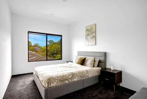 Una habitación blanca con una cama y una ventana en Urban Hideaway Pet Friendly, en Gold Coast 26 fotos más