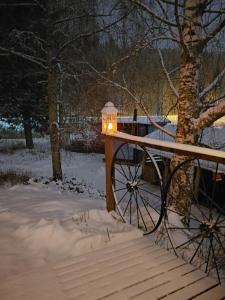 Eine Lampe auf einem Holztisch im Schnee in der Unterkunft A room (or 2 or 3) in a Lapland House of Dreams in Rovaniemi