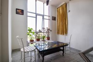 a dining room with a table and chairs and a window at Hotel O Kanchan Residency in Kota