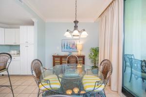 オレンジビーチにあるPhoenix on the Bay 1427 condoのガラスのテーブルと椅子のあるダイニングルーム