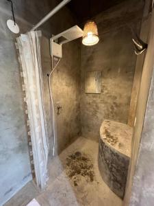 a bathroom with a shower with a stone tub at Casa 5 suítes - Vista para a Barra do Sahy in São Sebastião
