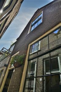 um edifício de tijolos com janelas e vasos de plantas sobre ele em Tannery Lane em Gouda