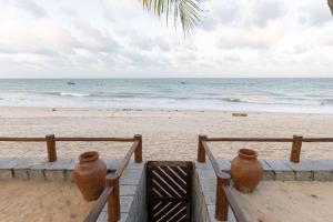 eine Treppe zum Strand mit zwei Vasen darauf in der Unterkunft Casa Mar: vista e acesso à praia | By Carpediem in Jacumã + 31 Fotos