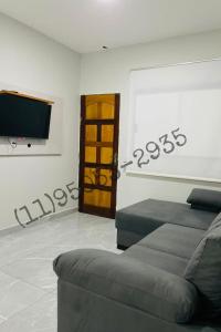 ein Wohnzimmer mit Couch und Flachbildfernseher in der Unterkunft Bertioga Rio da Praia in Bertioga