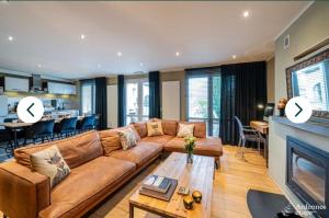 Una sala de estar con un sofá y una chimenea. en L'Hoursinne, en Érezée