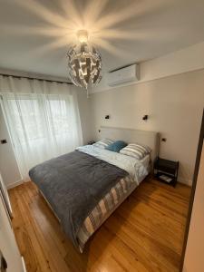 une chambre avec un grand lit et un lustre dans l'établissement Appartement, à Saint-Michel-de-Maurienne