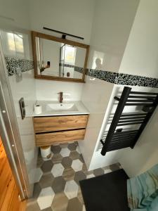 une salle de bain avec un lavabo et un miroir dans l'établissement Appartement, à Saint-Michel-de-Maurienne 14 autres photos