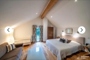 un dormitorio con una cama y un sofá en L'Hoursinne, en Érezée